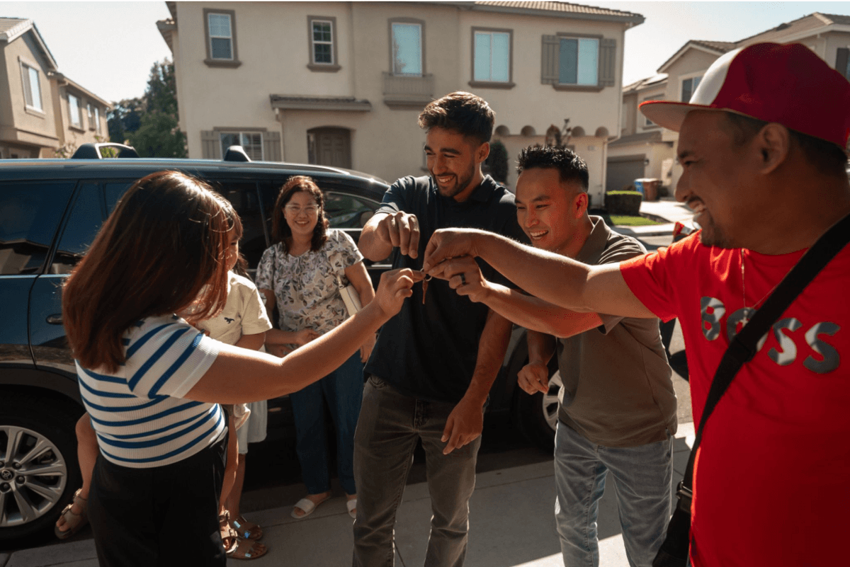 Jaden celebrating with clients as they receive their keys