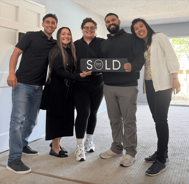 Jaden with clients holding a sold sign